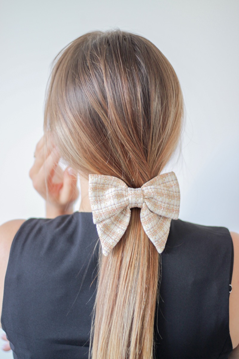 Moteris ryšinti smėlio spalvos languotą kaspiną